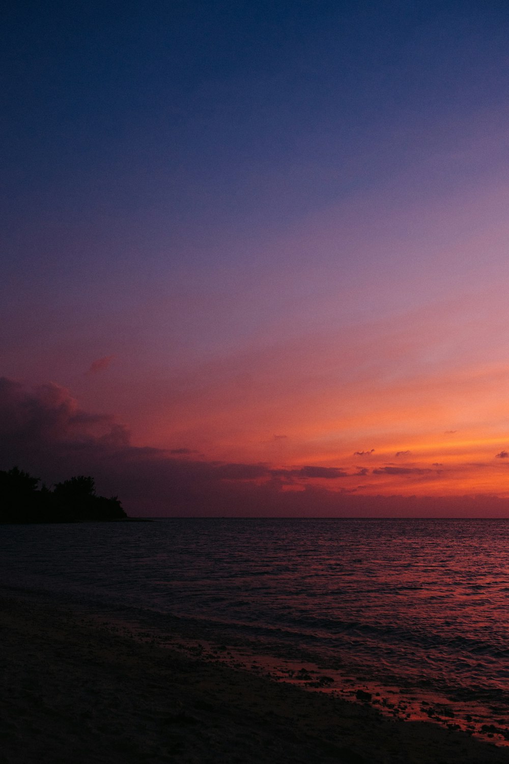 夕暮れ時の海辺の山のシルエット