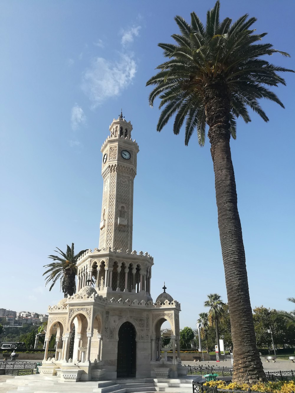 Edificio in cemento beige vicino alla palma sotto il cielo blu durante il giorno