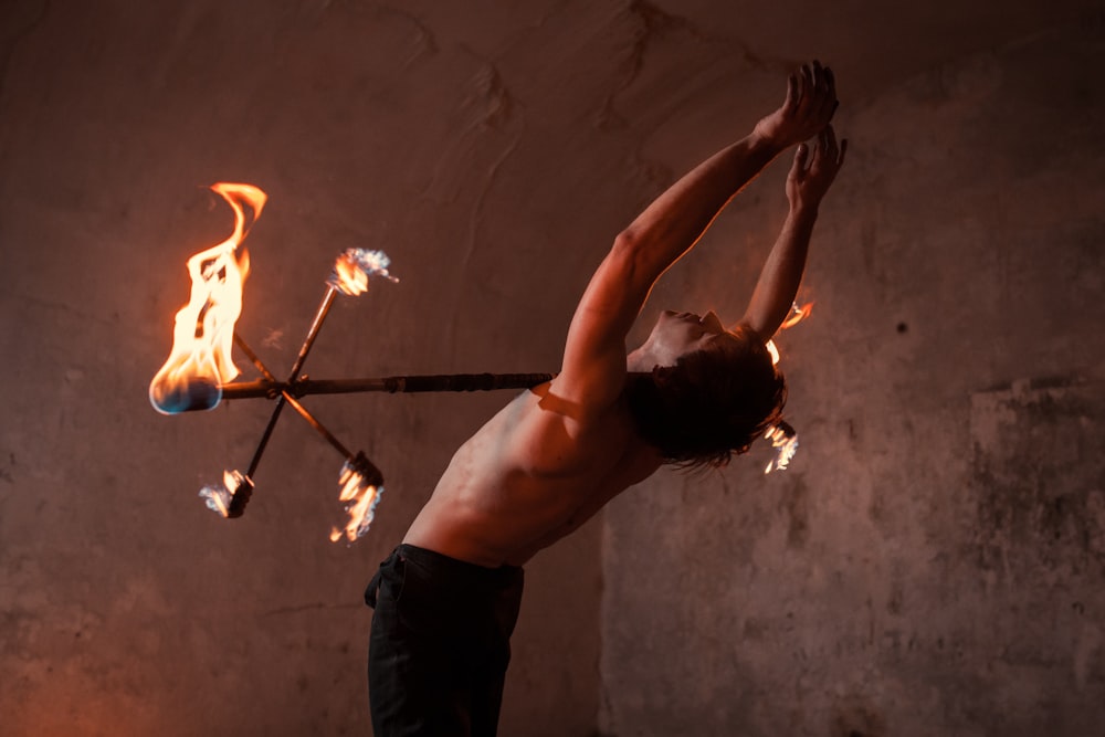 homem em calças pretas segurando o fogo