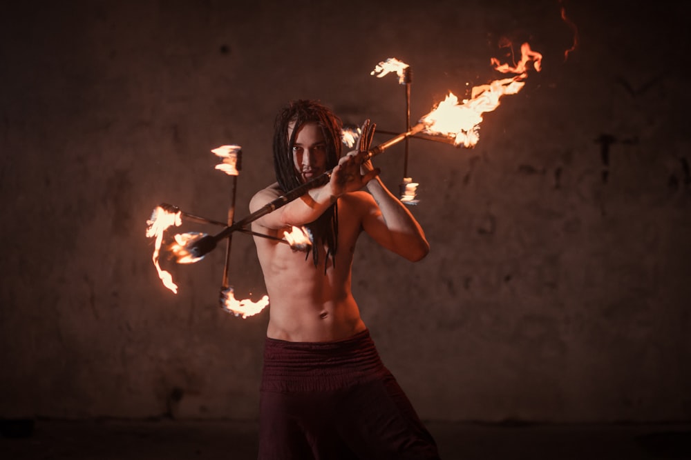 woman in black tank top holding a stick with fire