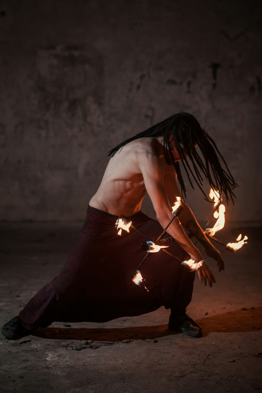 topless man in black shorts holding fire