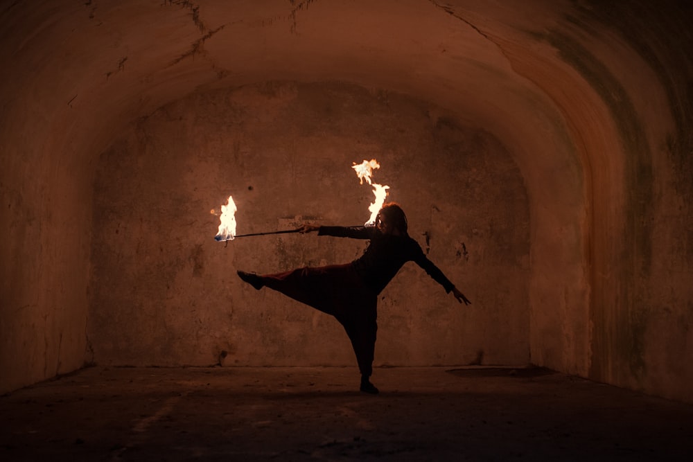 man in black shirt and pants holding fire