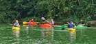 people riding on red kayak on river during daytime