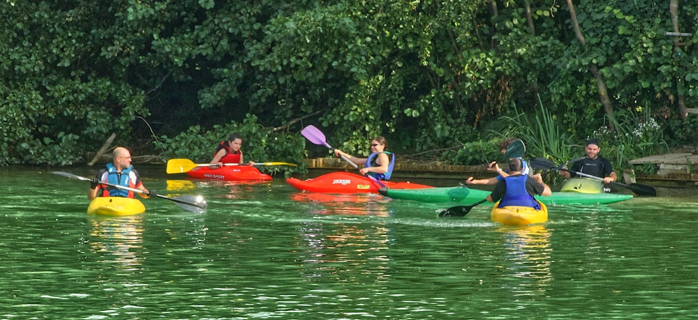 people riding on red kayak on river during daytime