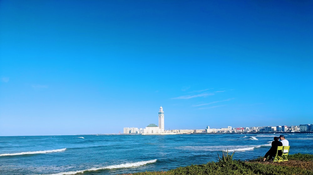 white lighthouse near body of water during daytime