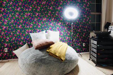 A cozy classic bean bag chair in soft fabric, placed in a bright living room corner