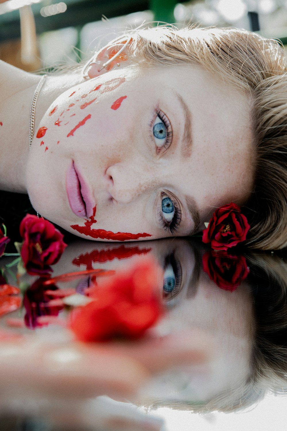 Mujer en camisa blanca con flor roja en la oreja