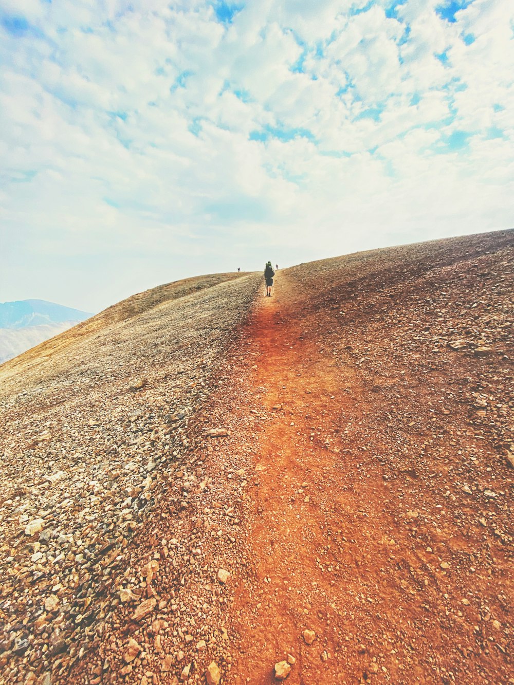 person walking on brown sand under blue sky during daytime