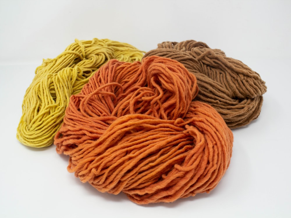 yellow and brown yarn on white surface