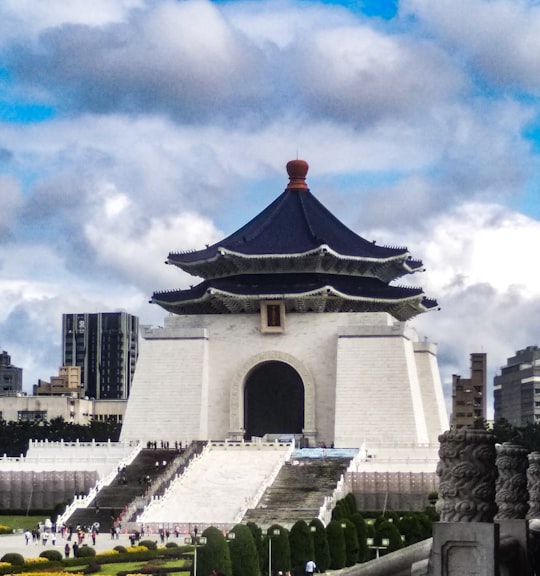 gray and red concrete building under white clouds during daytime in Chiang Kai-shek Memorial Hall Taiwan