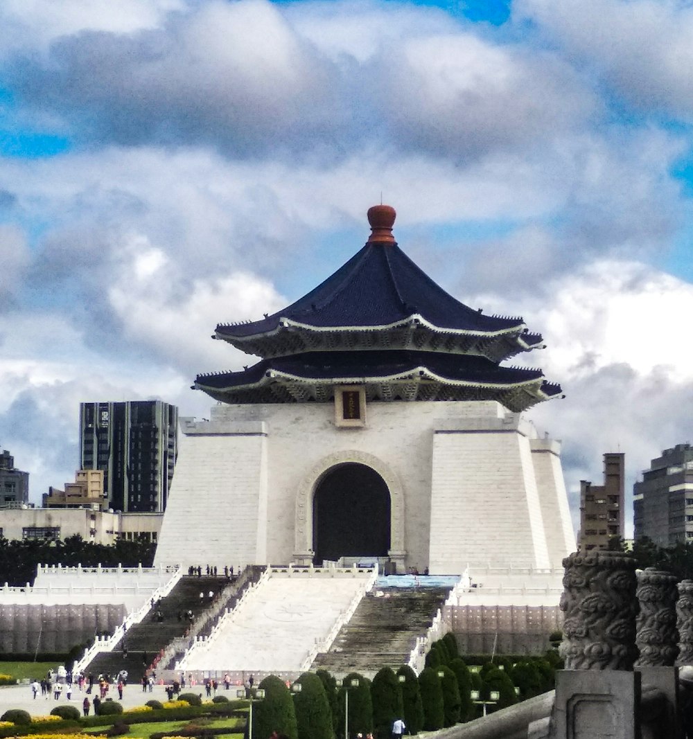 gray and red concrete building under white clouds during daytime