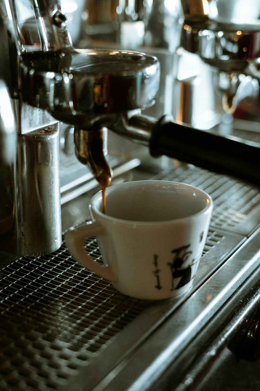 white ceramic mug on silver and black espresso machine