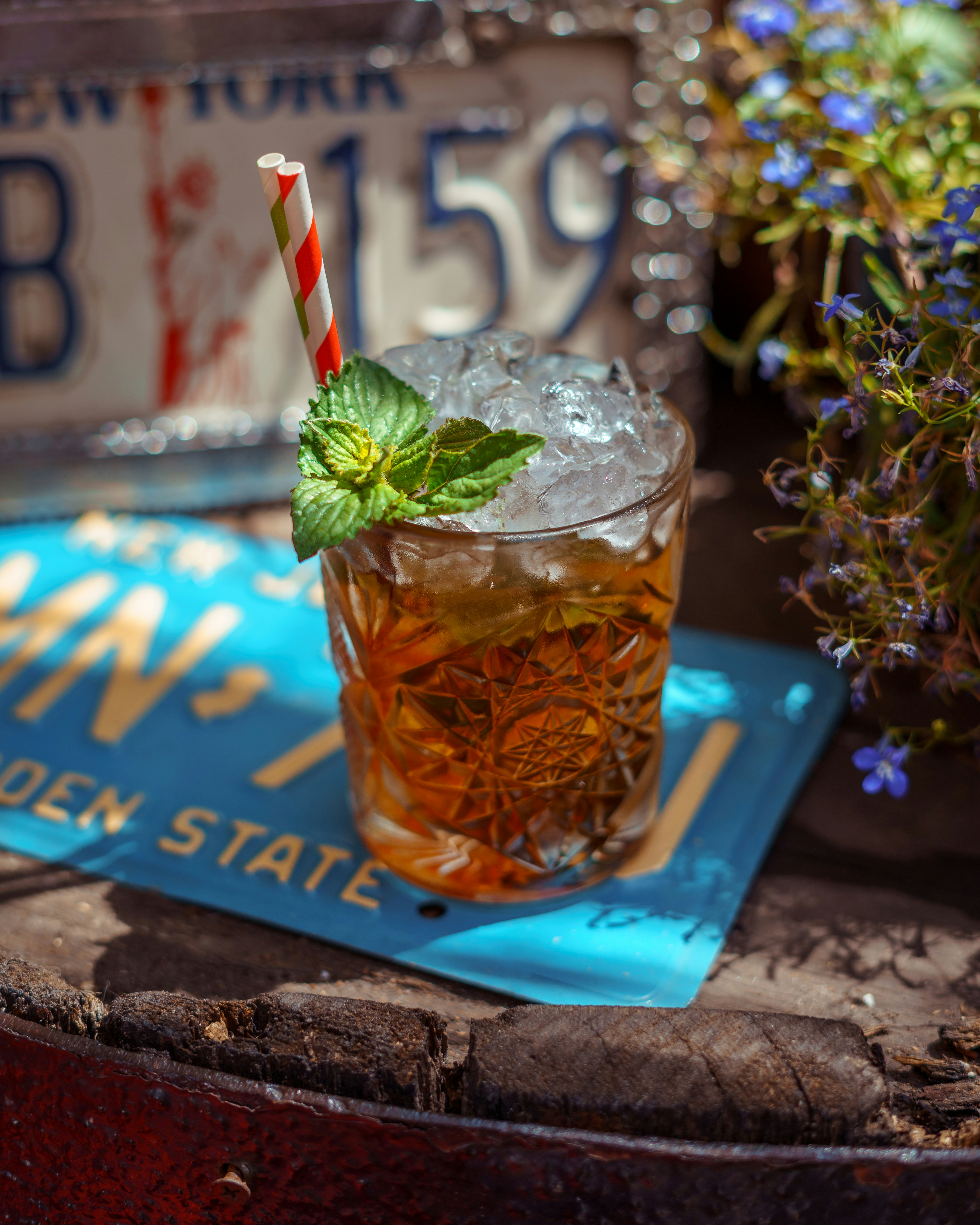 氷と緑のストローが入った透明なグラス