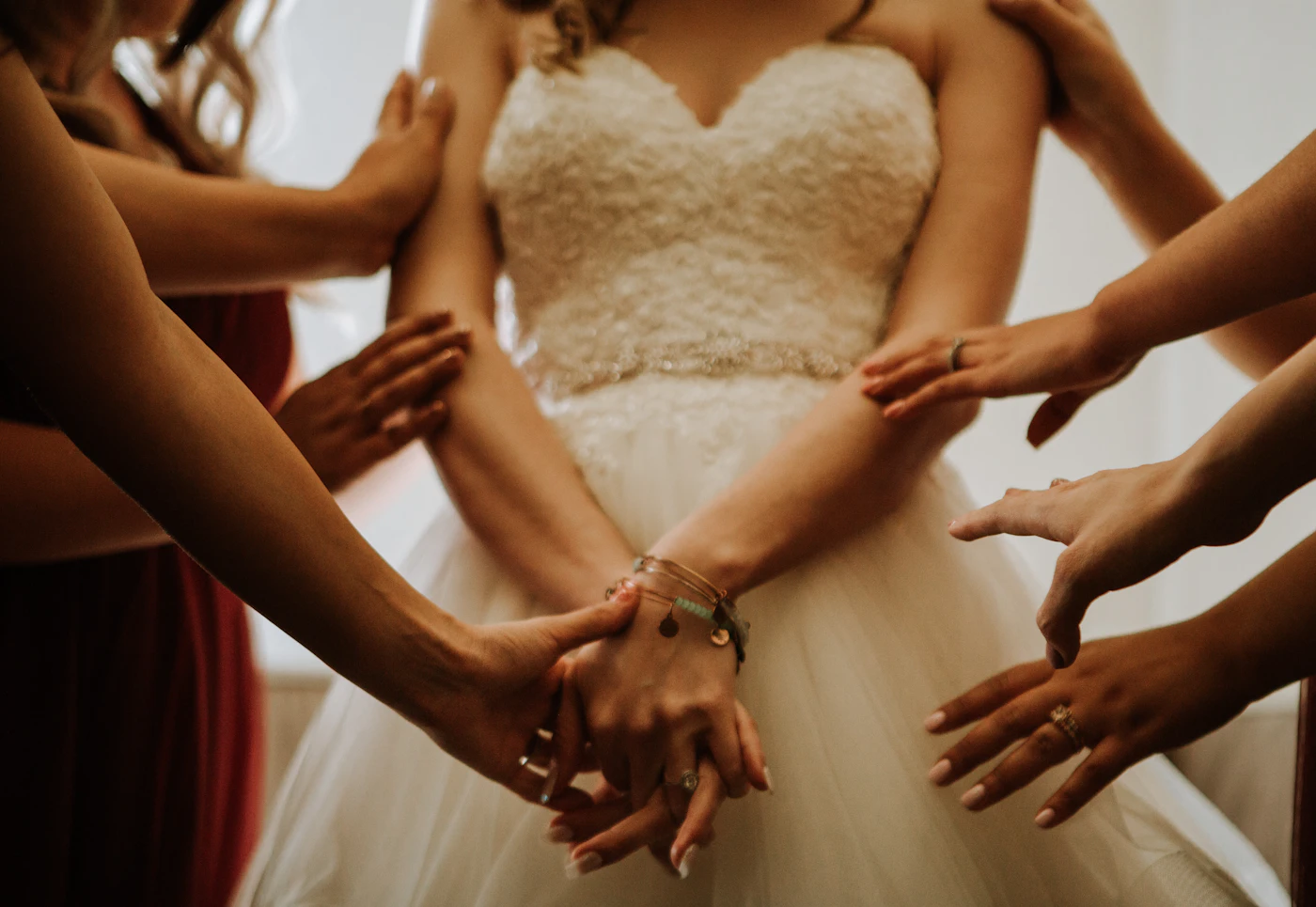Alteration tips for off-the-rack wedding dresses — A seamstress pins the hem of a bride's off-the-rack wedding gown in a studio.