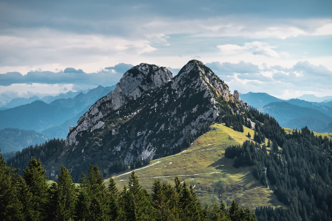 green trees on mountain under cloudy sky during daytime