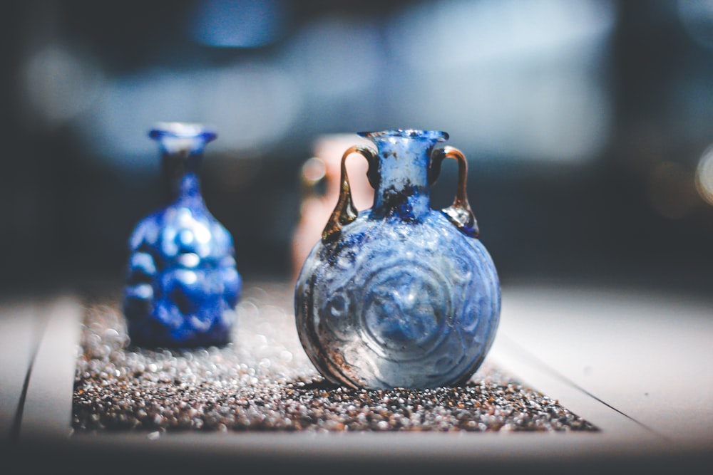 blue glass vase on white and black marble table