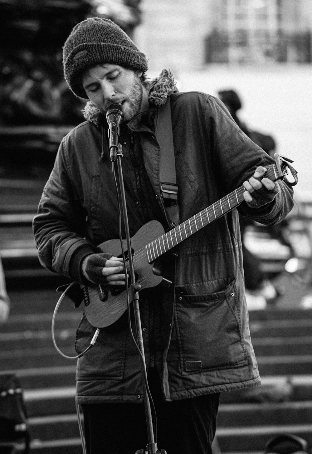 man in black jacket playing guitar