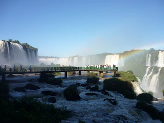 Stunning panoramic view of Iguazu Falls with vibrant rainbows arching over the cascading water.