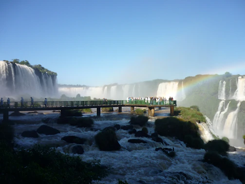 Stunning panoramic view of Iguazu Falls with vibrant rainbows arching over the cascading water.