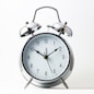 silver and white analog alarm clock
