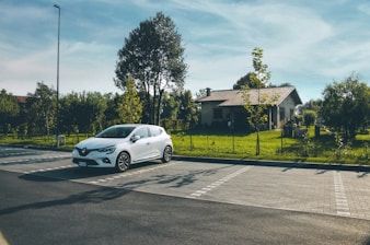 A family smiling next to their new car parked outside their home