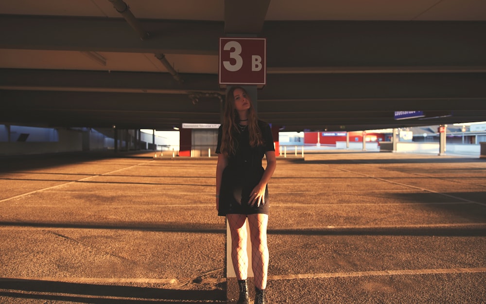 woman in black coat standing on brown field