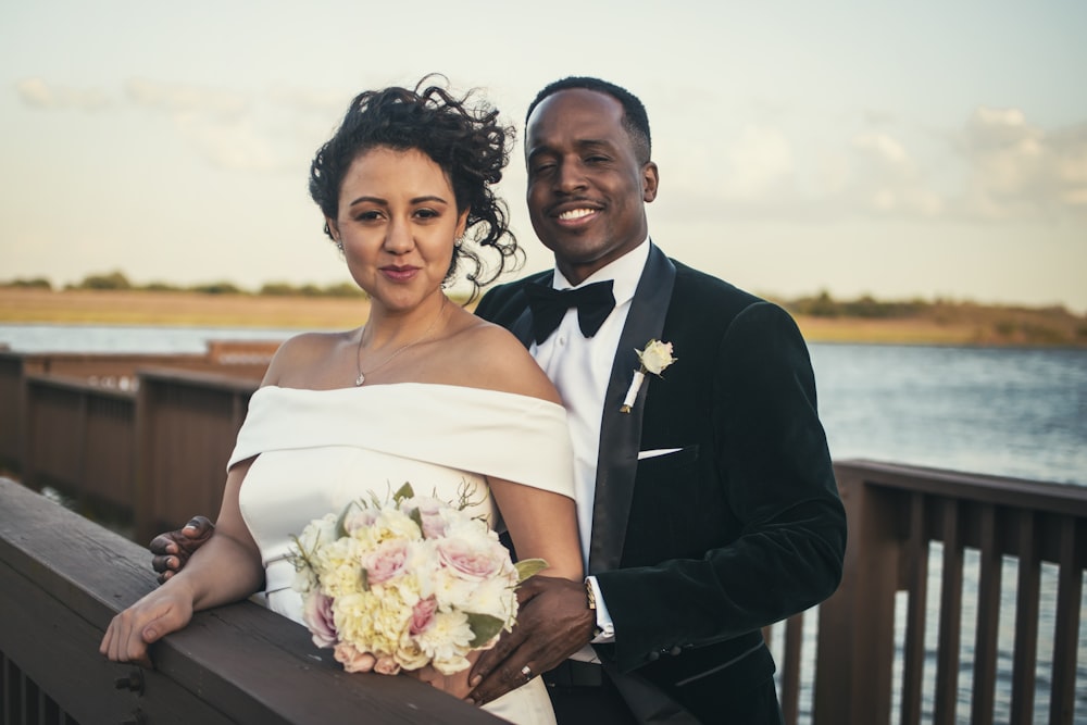 man in black suit jacket holding bouquet of flowers