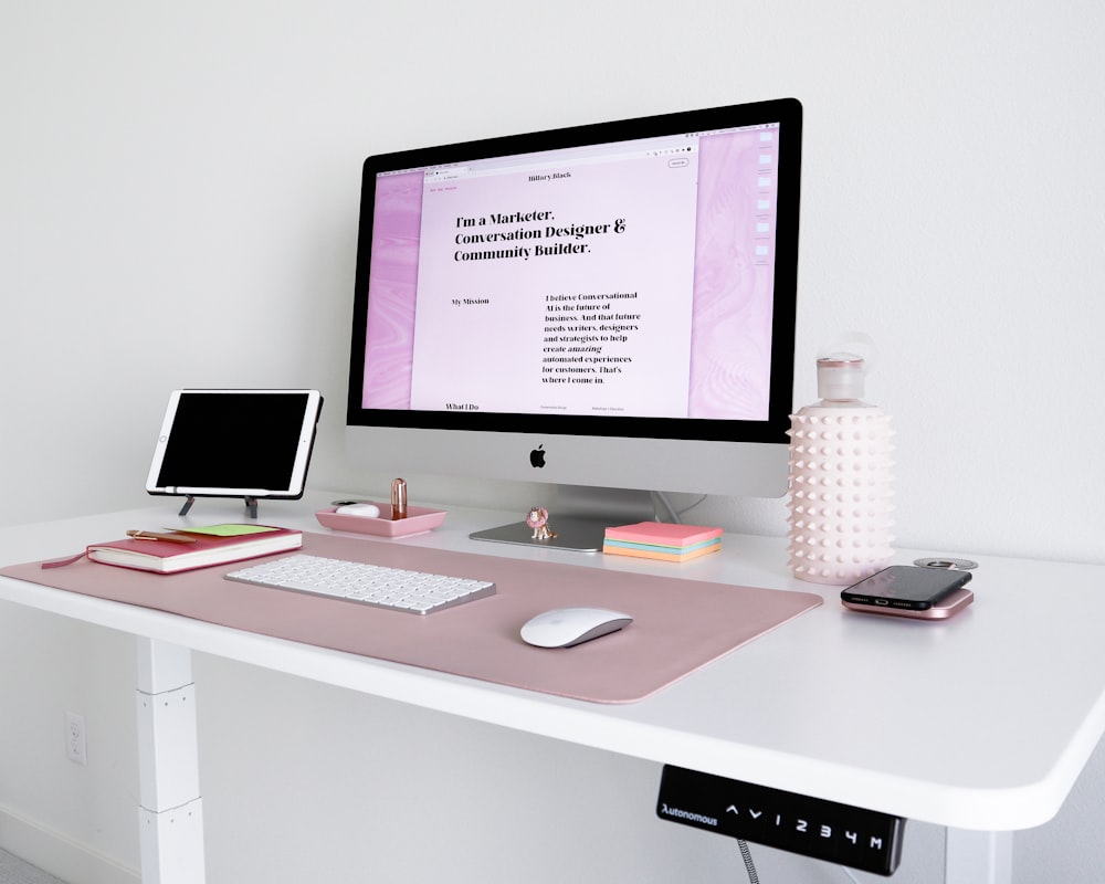 iMac plateado sobre escritorio de madera blanca
