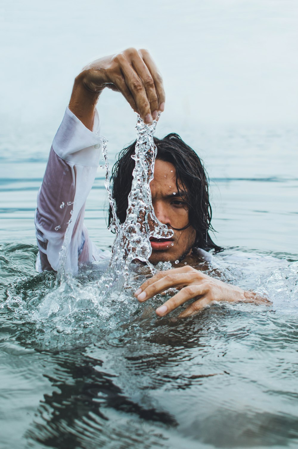 woman in white long sleeve shirt in water