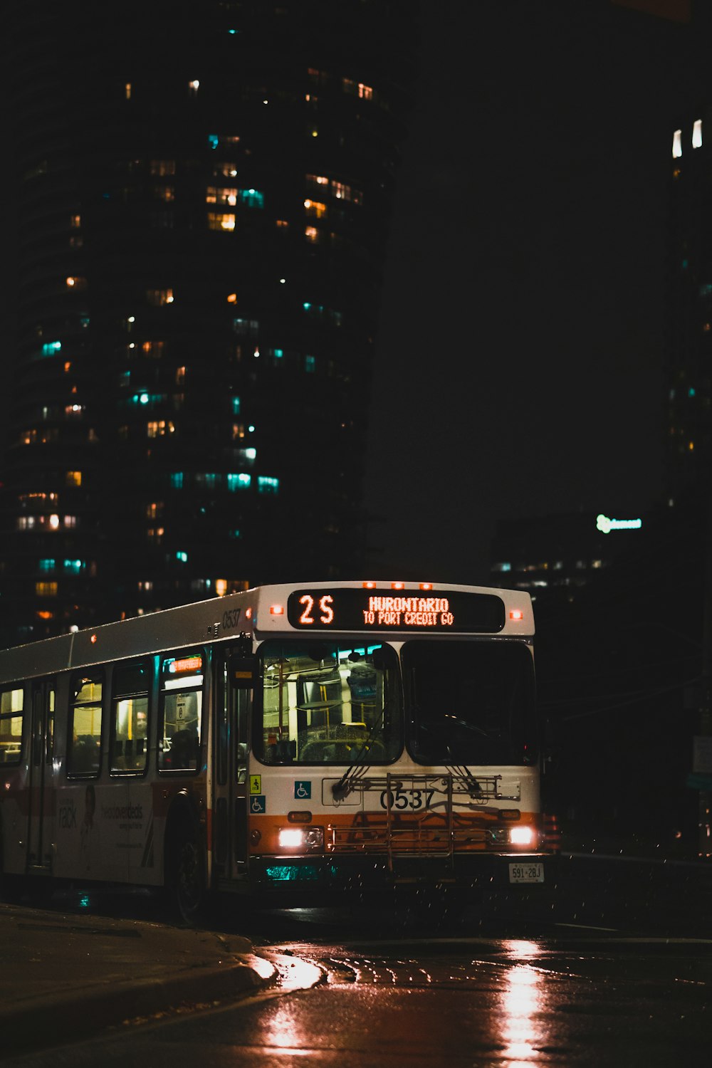 야간 도로에서 빨간색과 흰색 버스