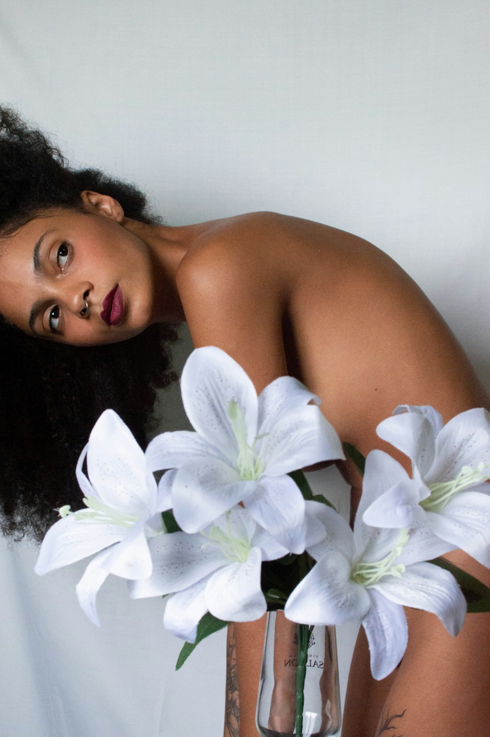 woman holding white petaled flowers