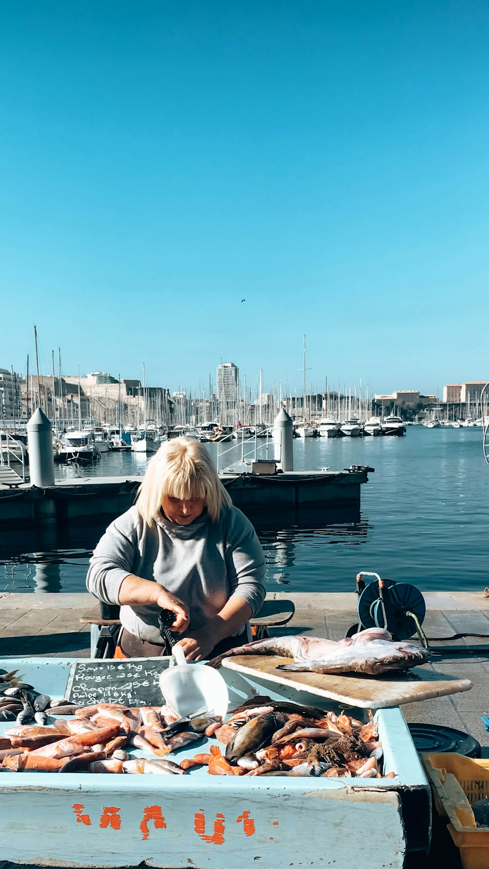 woman in gray long sleeve shirt sitting on boat during daytime