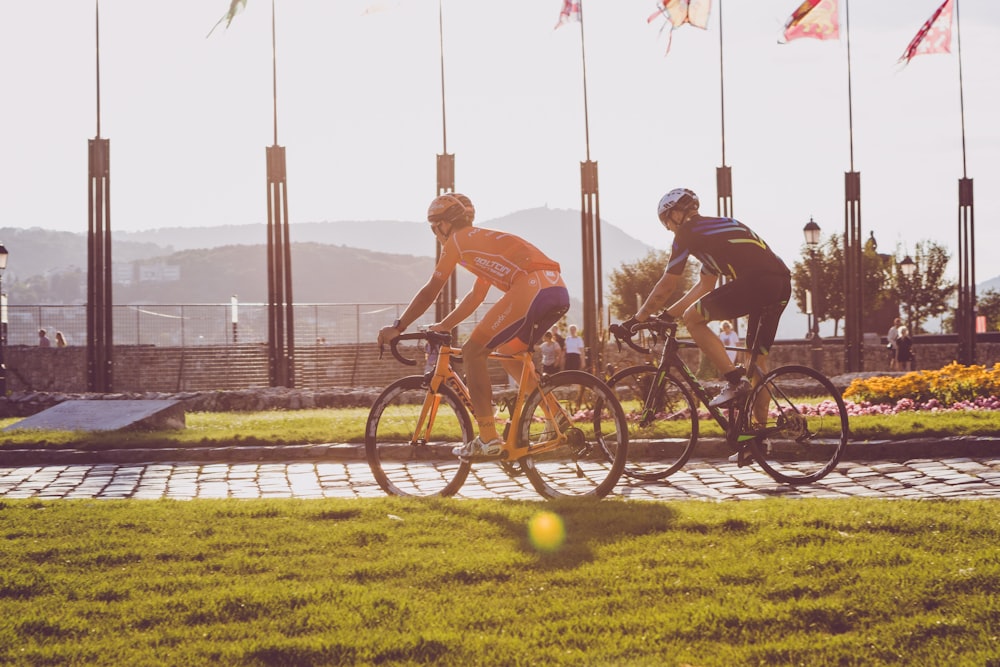 people riding bicycles on green grass field during daytime