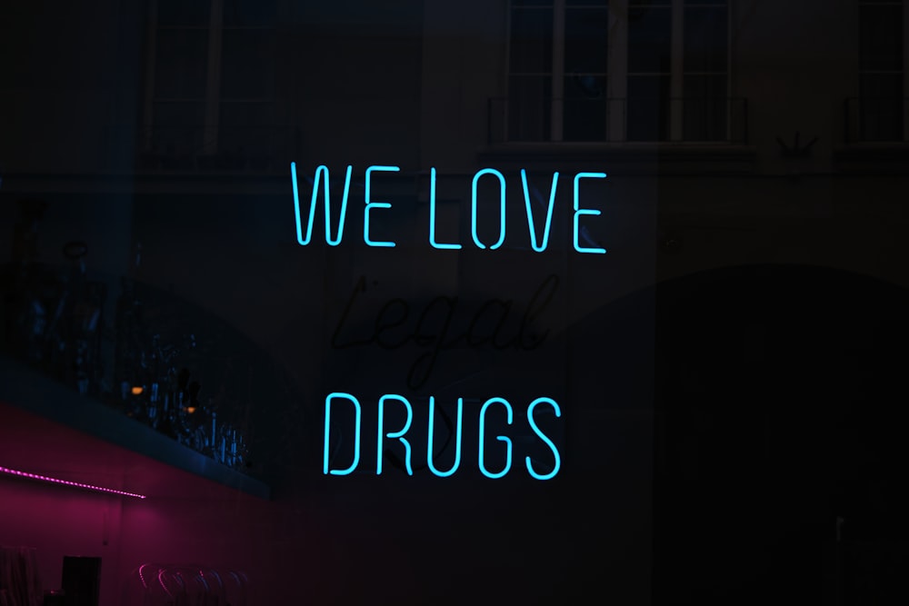 a neon sign that says we love drugs