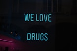a neon sign that says we love drugs