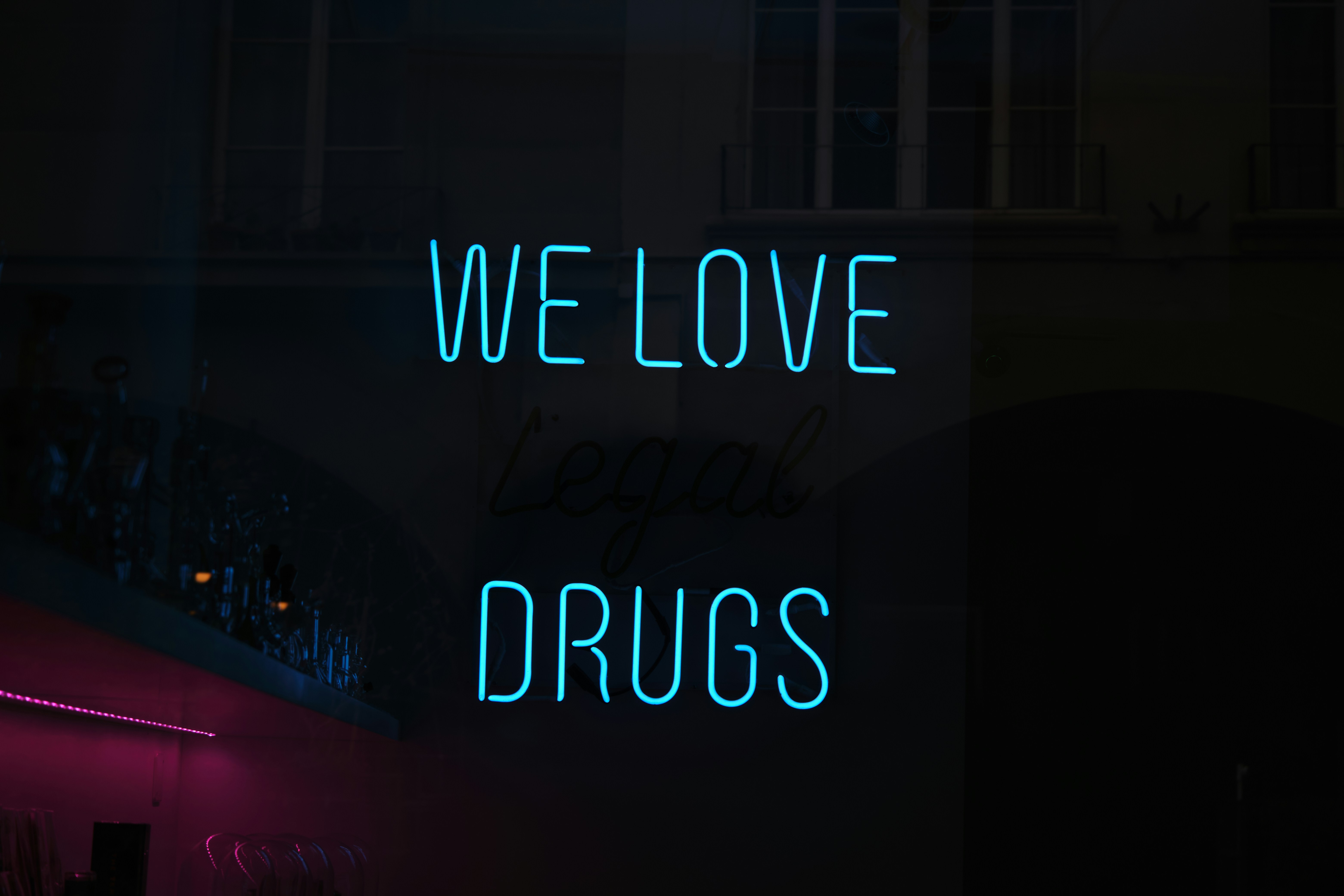 a neon sign that says we love drugs