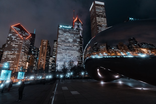 black car on road near high rise buildings during night time