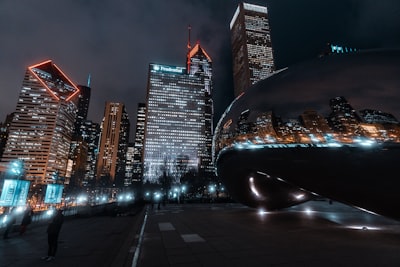 black car on road near high rise buildings during night time illinois teams background