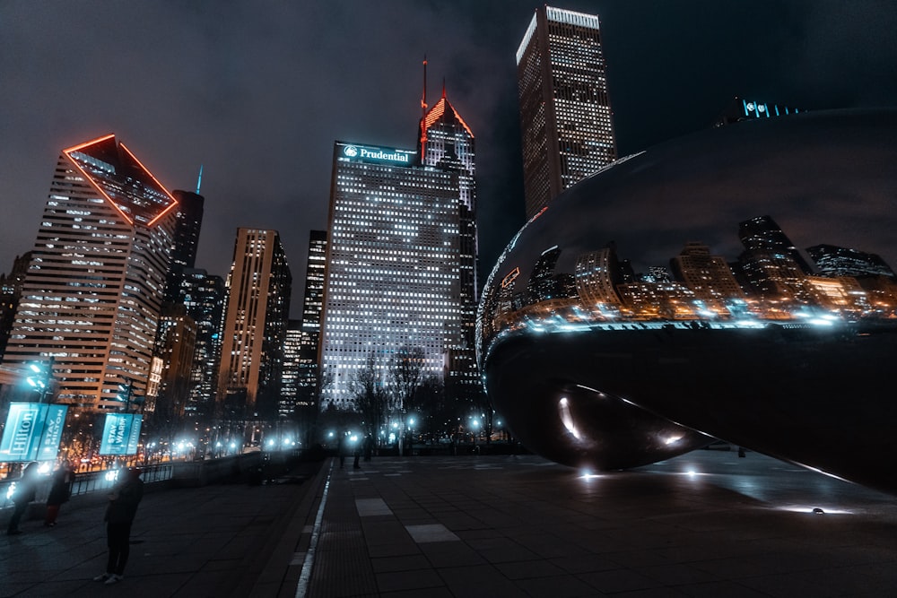 black car on road near high rise buildings during night time