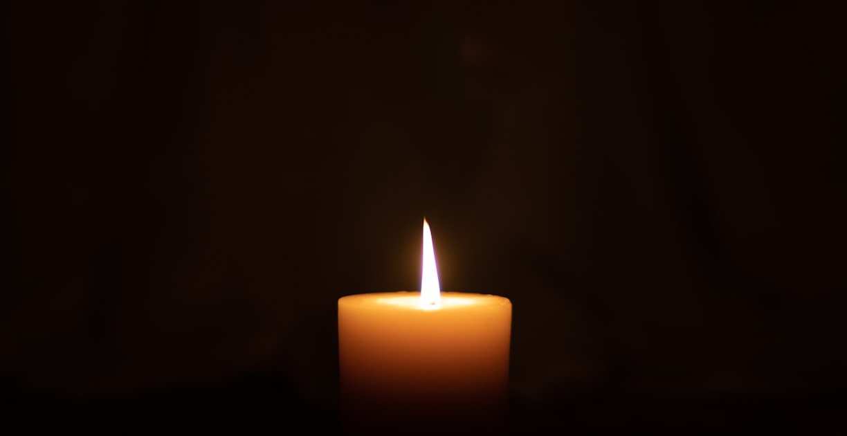 lighted candle in dark room