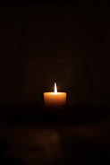lighted candle in dark room