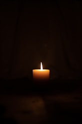lighted candle in dark room