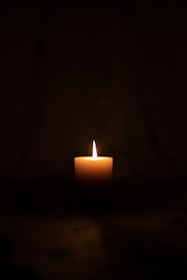 lighted candle in dark room