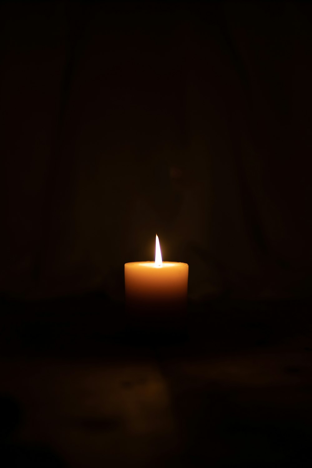lighted candle in dark room