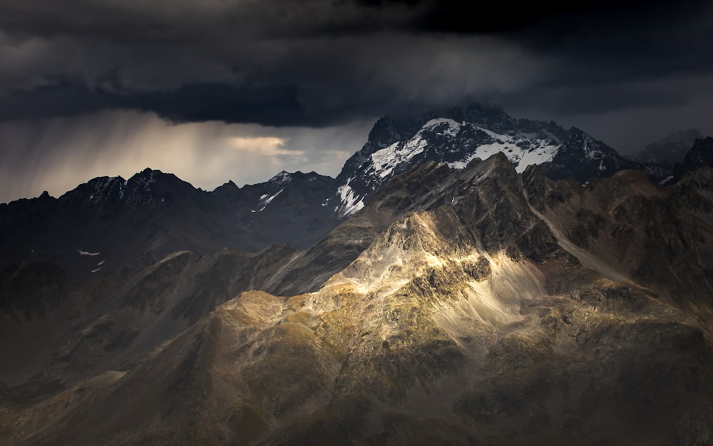 snow covered mountain under cloudy sky during daytime