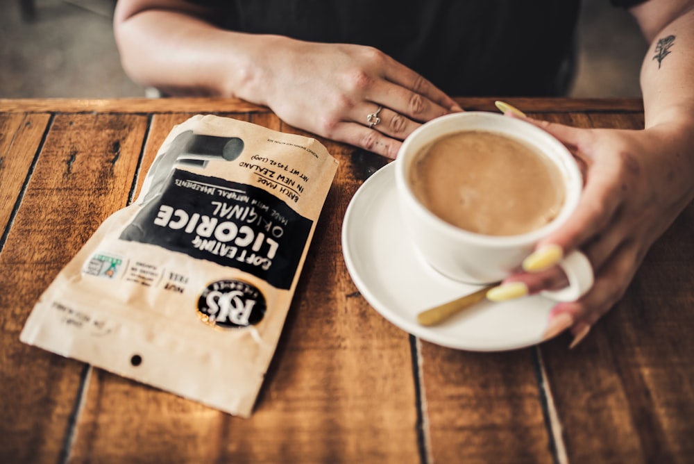 person holding white ceramic mug with coffee