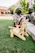 A happy customer sitting in a foldable Adirondack chair on a sunny patio.
