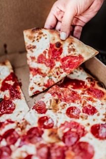 Close-up of a hand picking up a warm, crusty roll from a delivery box.