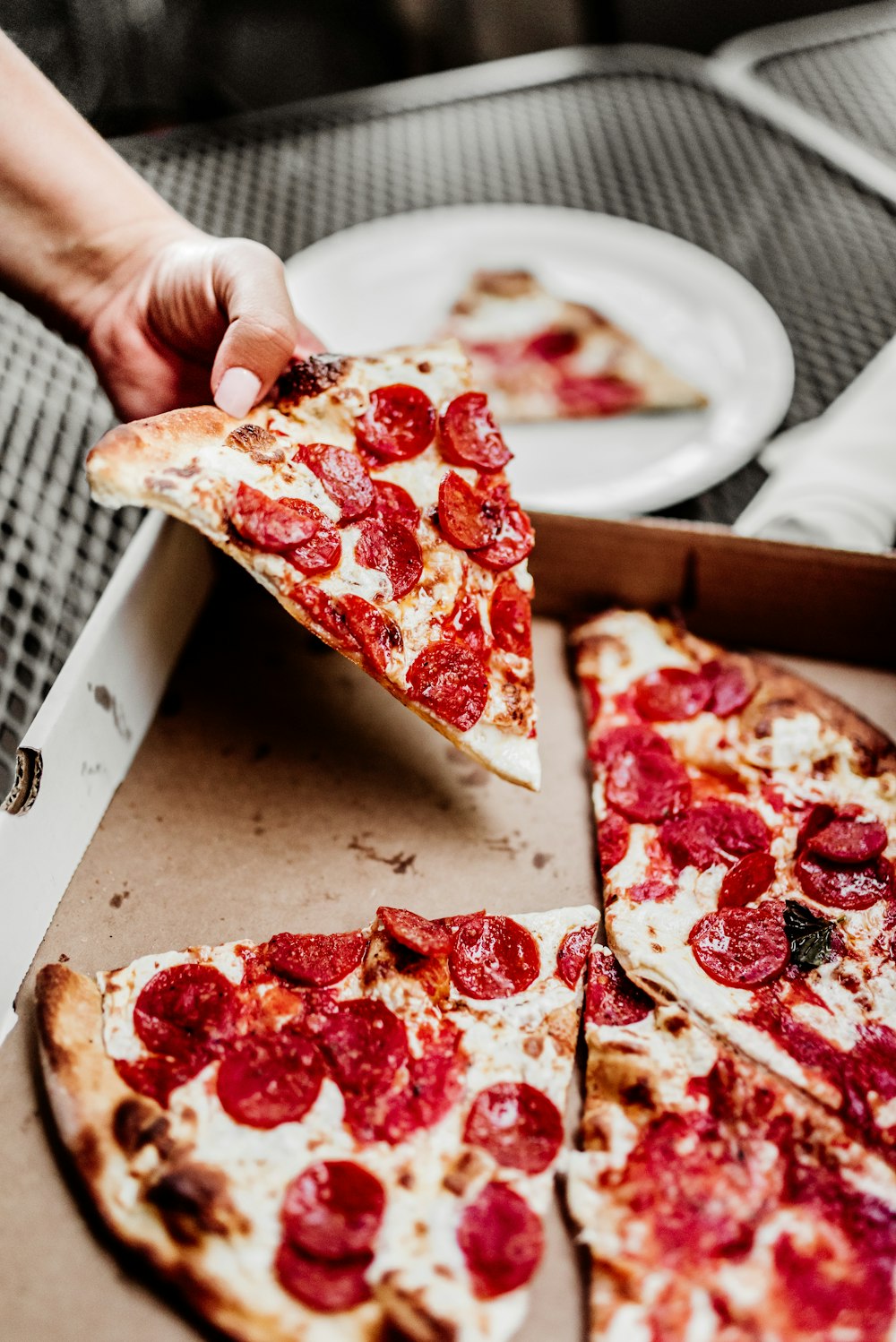 Pizza en rodajas en plato de cerámica blanca