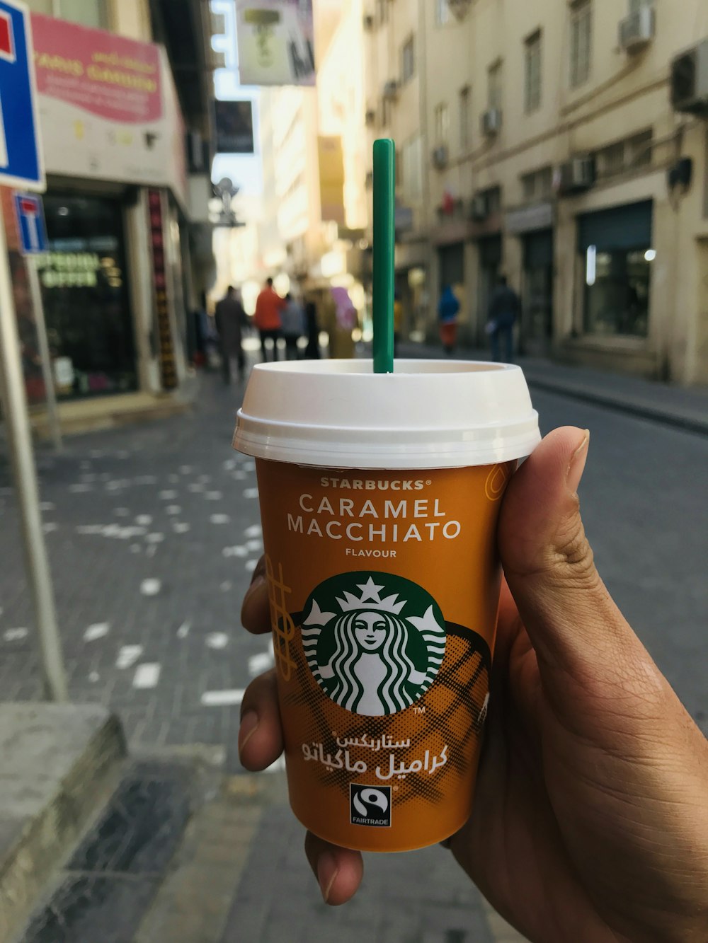 person holding brown and white disposable cup